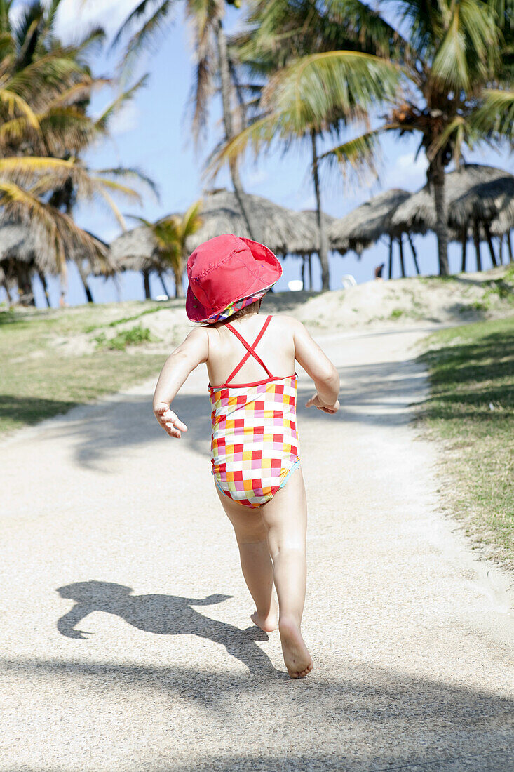 Child Running Down A Path Barefoot Towards The Beach; Varadero, Cuba