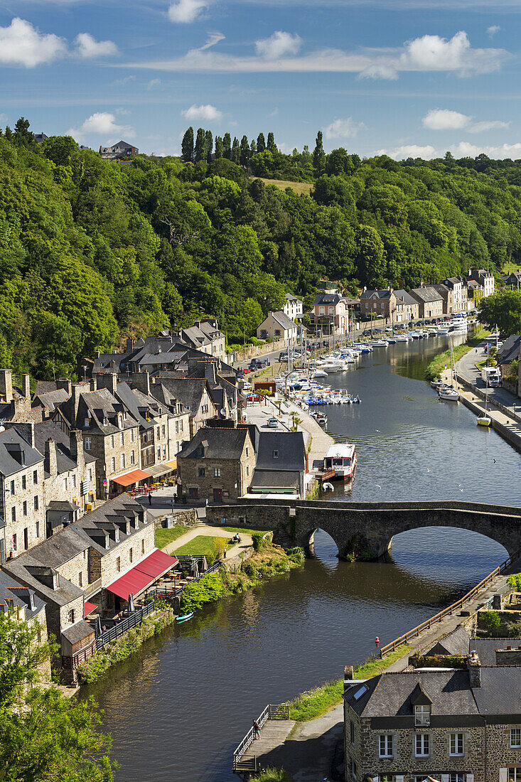 Treed Valley Riverside Town, Stone Bridge And Boats In The Harbour With Blue Sky And Clouds; Dinan, Brittany, France