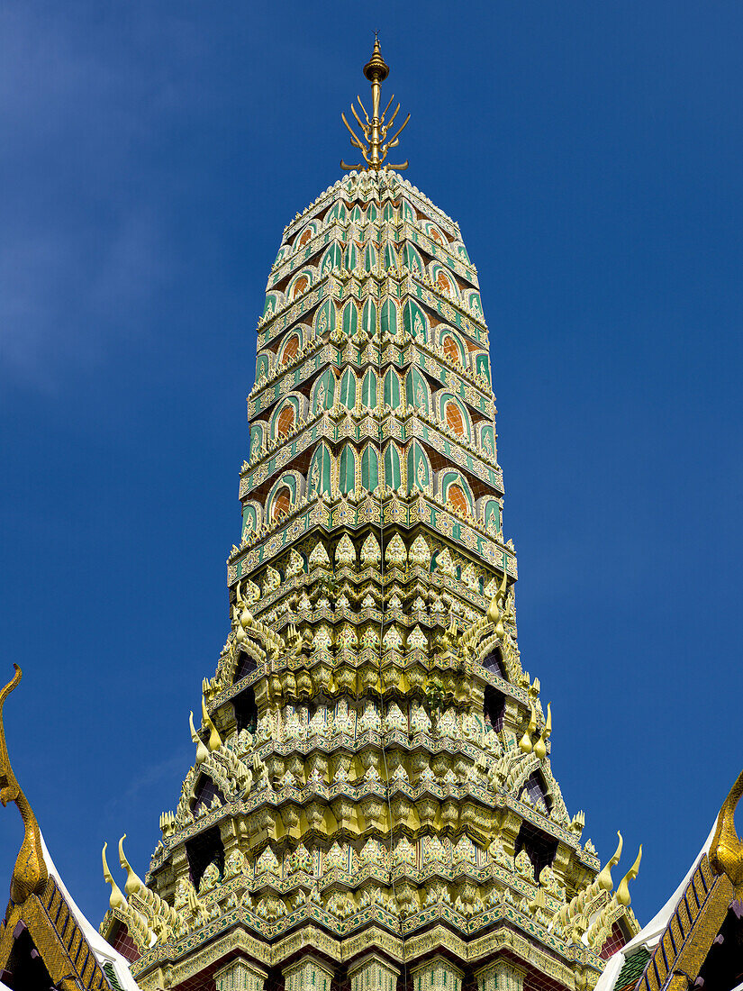 Grüner und goldener Turm vor blauem Himmel, Tempel des Smaragdbuddhas (Wat Phra Kaew); Bangkok, Thailand