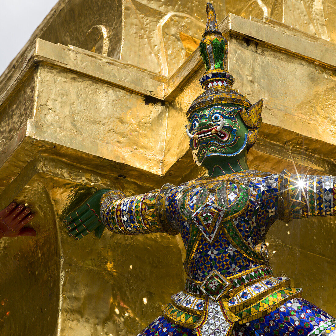 Colourful, Ornate Statue In From Of A Gold Wall, Temple Of The Emerald Buddha (Wat Phra Kaew); Bangkok, Thailand