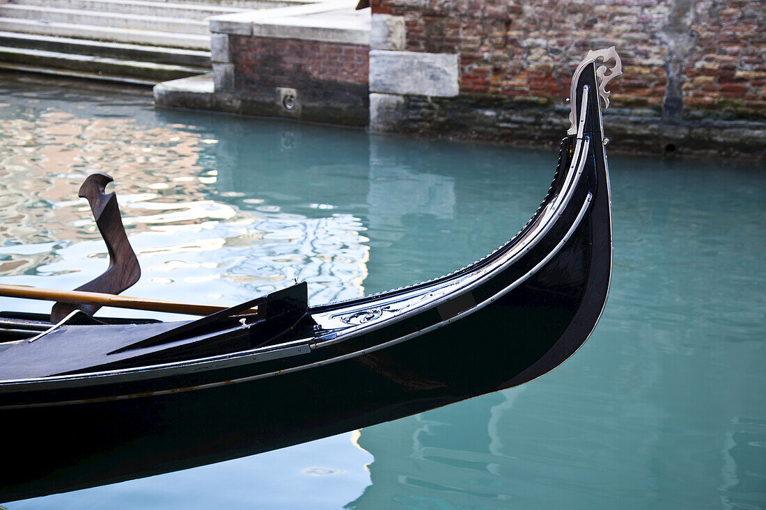 Front Of A Gondola In A Canal With Turquoise Water; Venice, Italy