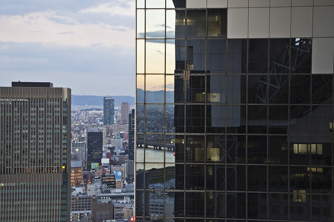 Bürogebäude mit Glaswänden, in denen sich andere Gebäude spiegeln; Osaka, Japan