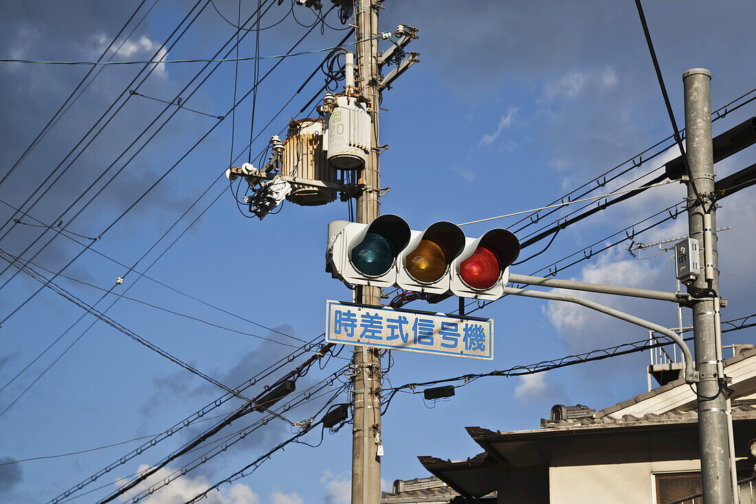 Ampel mit Straßenschild und Übertragungsleitungen; Kyoto, Japan