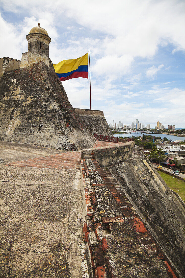 Castillo San Felipe De Barajas und kolumbianische Flagge mit Cartagena New City im Hintergrund; Cartagena, Kolumbien