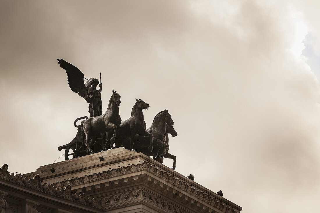 Auf beiden Seiten der Dachterrasse reitet die Göttin Victoria auf Quadrigas; Rom, Italien