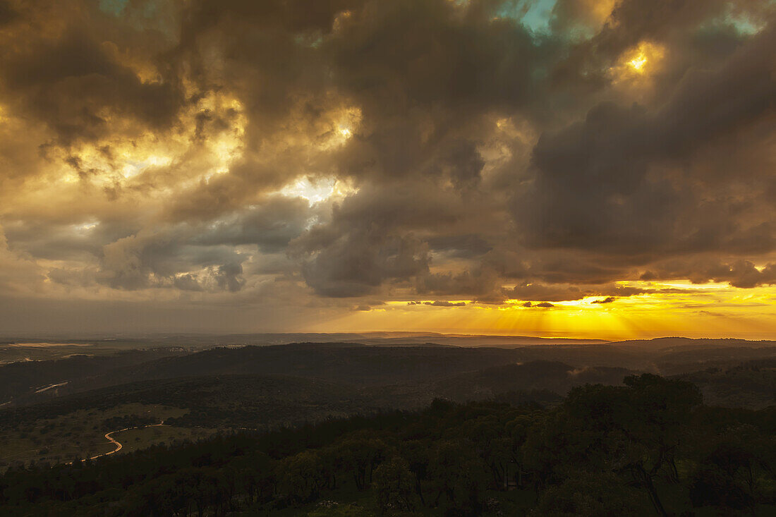 Goldener Sonnenuntergang mit leuchtenden Wolken und silhouettierter Landschaft; Israel