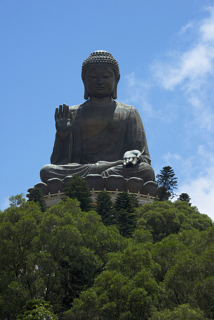 Großer Buddha auf einer Bergkuppe über grünen Bäumen; Hongkong