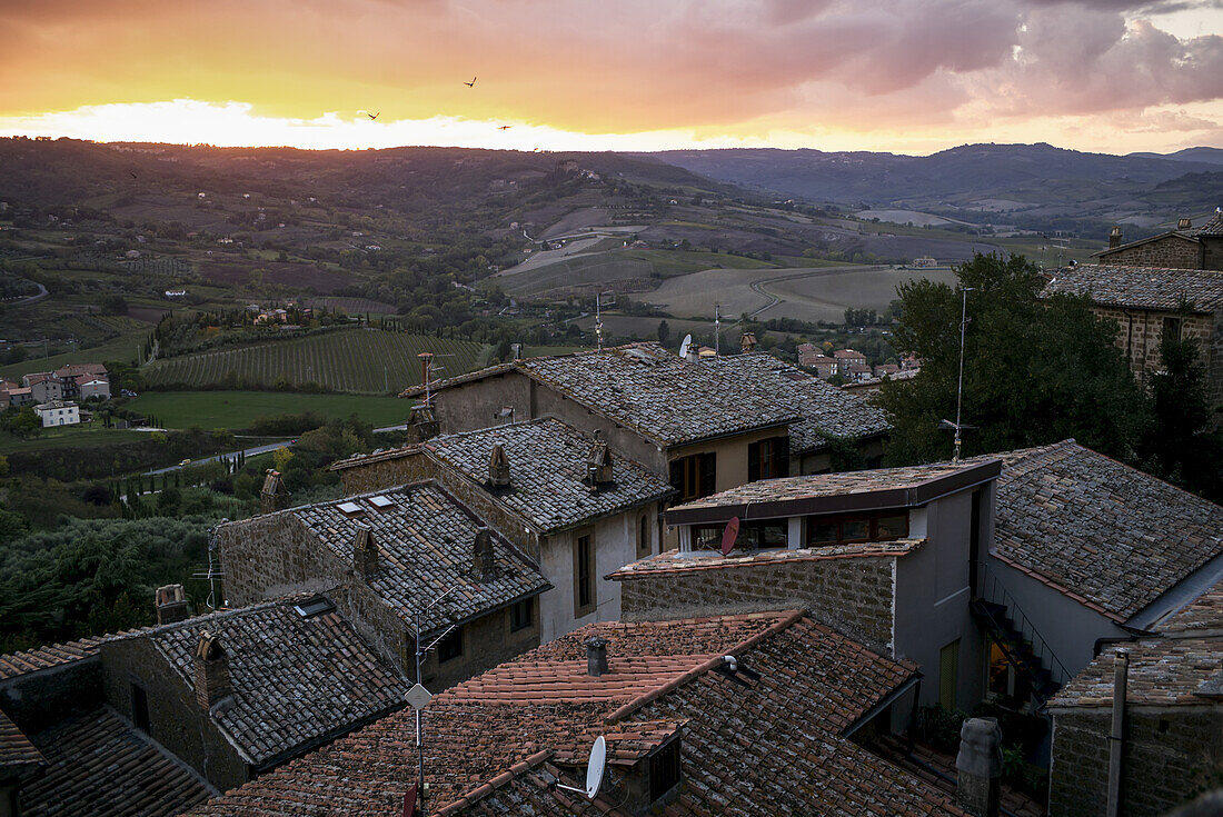 Rooftops Of Houses In The Foreground And Rolling Hills In The Distance At Sunset; Orvieto, Umbria, Italy