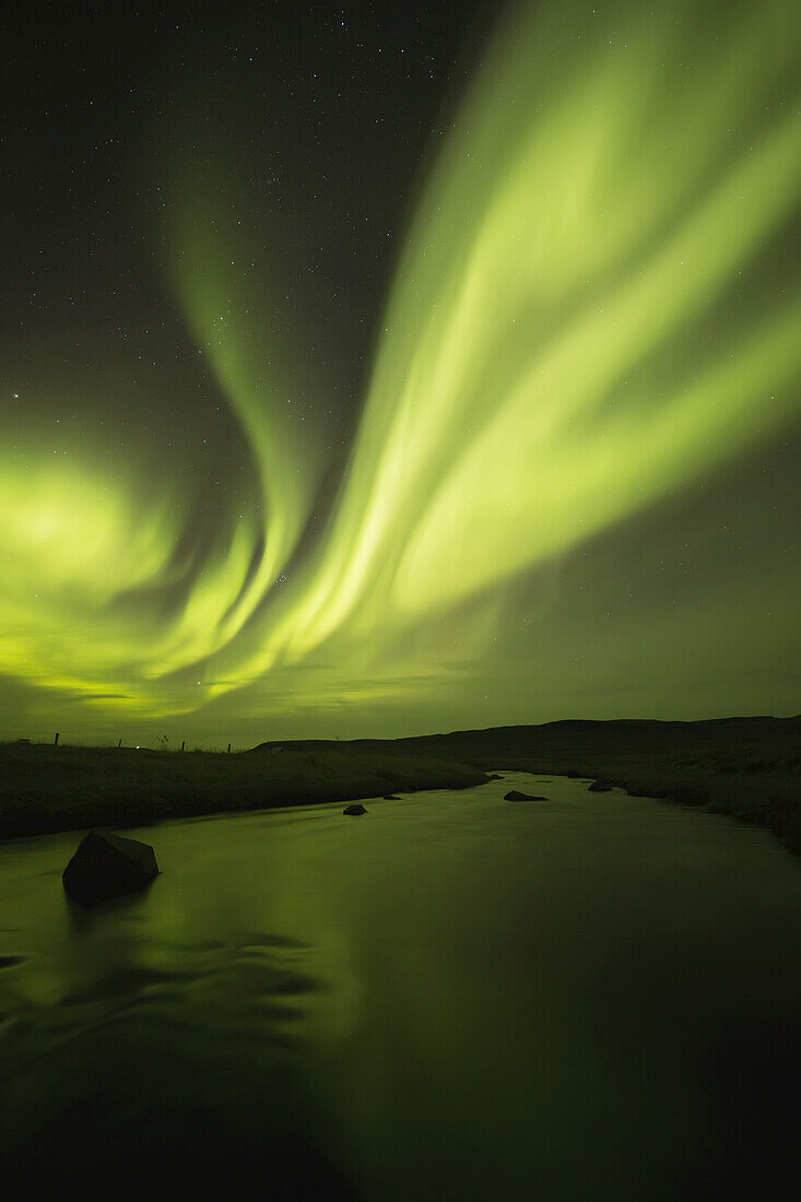Nordlicht, oder Aurora Borealis, leuchtend über einem Bach; Island