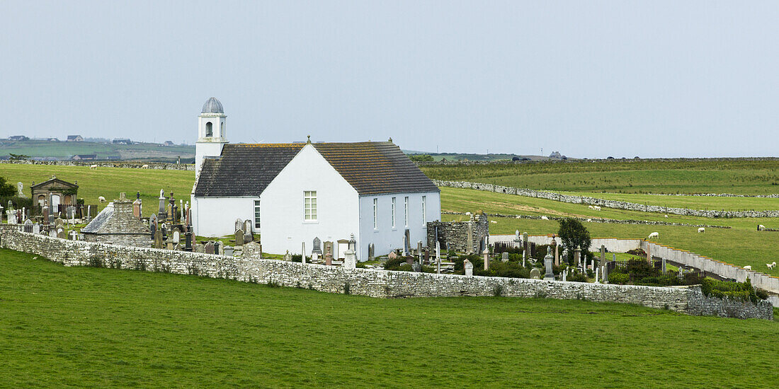 A White Church And Cemetery Surrounded By A Stone Fence; Latheron, Scotland