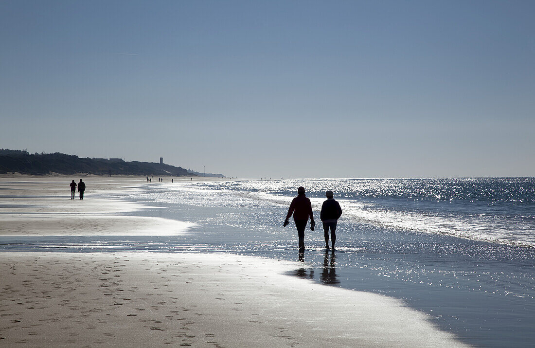 Strandspaziergang am Rande des Wassers, in der Nähe von Chiclana De La Frontera; Andalusien, Spanien