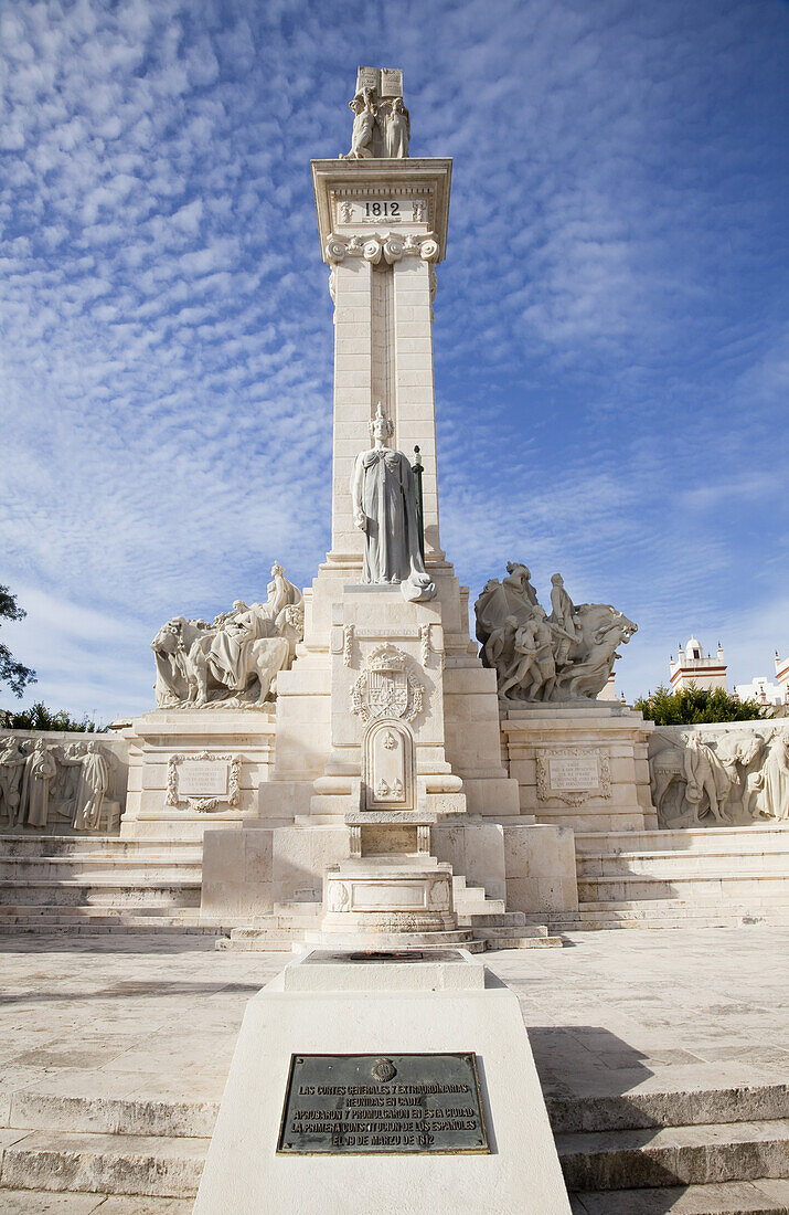 Human Figures Carved Into A Wall And A Tower With A Statue Against A Blue Sky With Cirrus Clouds; Andalusia, Spain