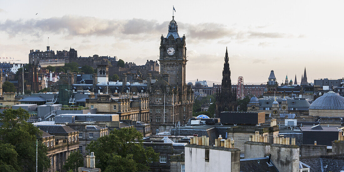 Großer Uhrenturm über einer Stadtlandschaft bei Sonnenaufgang; Edinburgh, Schottland