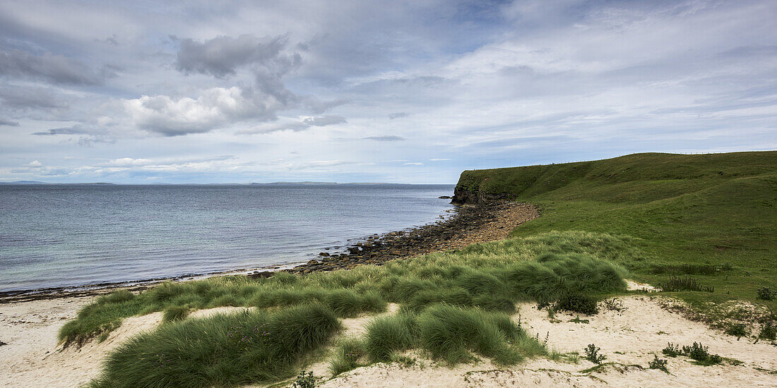 Sand und Gras an der Küste mit Blick auf die Küstenlinie; Caithness, Schottland