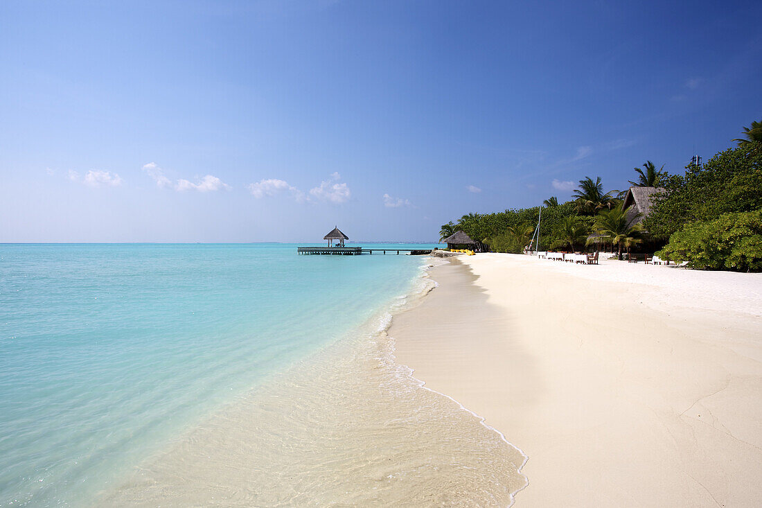 Klassischer weißer Sandstrand mit blauem Meer und Überwasser-Cabana