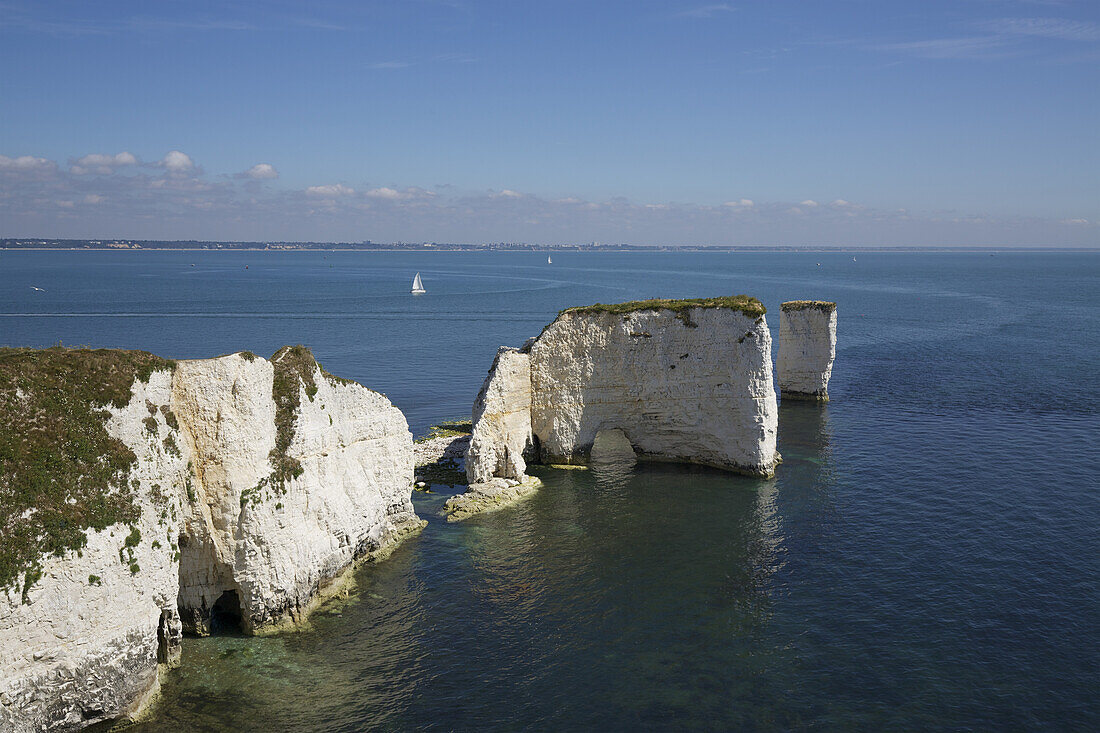Dramatic Limestone Cliffs And Off Shore Stacks With Archways And Caves Set In Calm Blue Sea