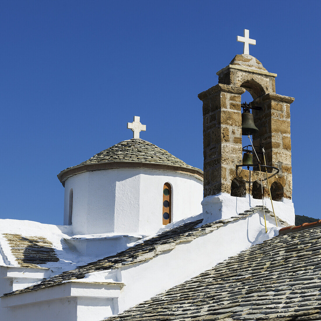 A Church Building With Crosses And Bells On The Rooftop; Panormos, Skopelos, Greece