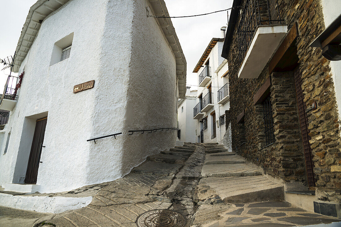 Eine schräge Straße zwischen Häusern in Pampaneira, einem der berühmtesten Dörfer in Alpujarra; Provinz Granada, Andalusien, Spanien