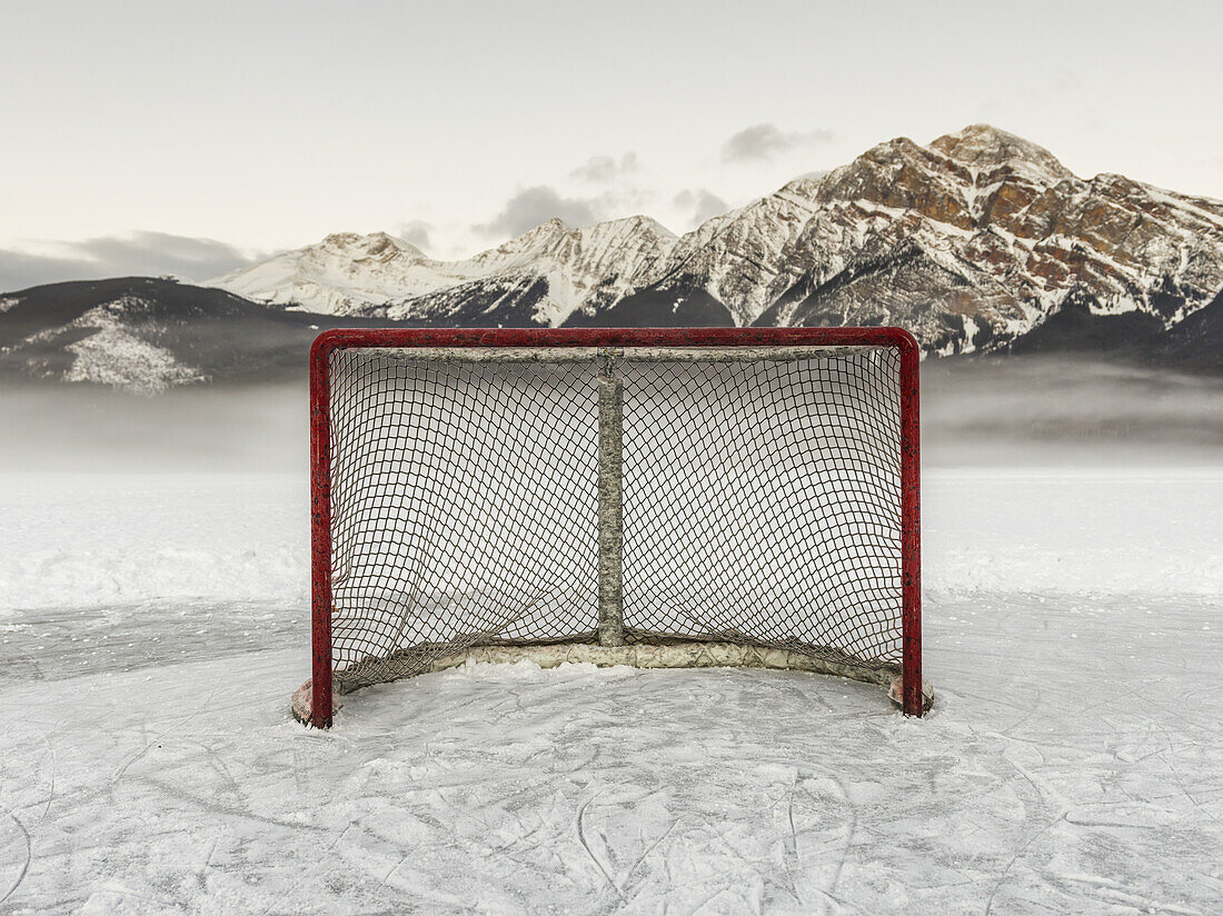 Ein Hockeynetz auf dem gefrorenen Pyramid Lake mit der zerklüfteten Bergkette der kanadischen Rockies im Hintergrund, Jasper National Park; Alberta, Kanada
