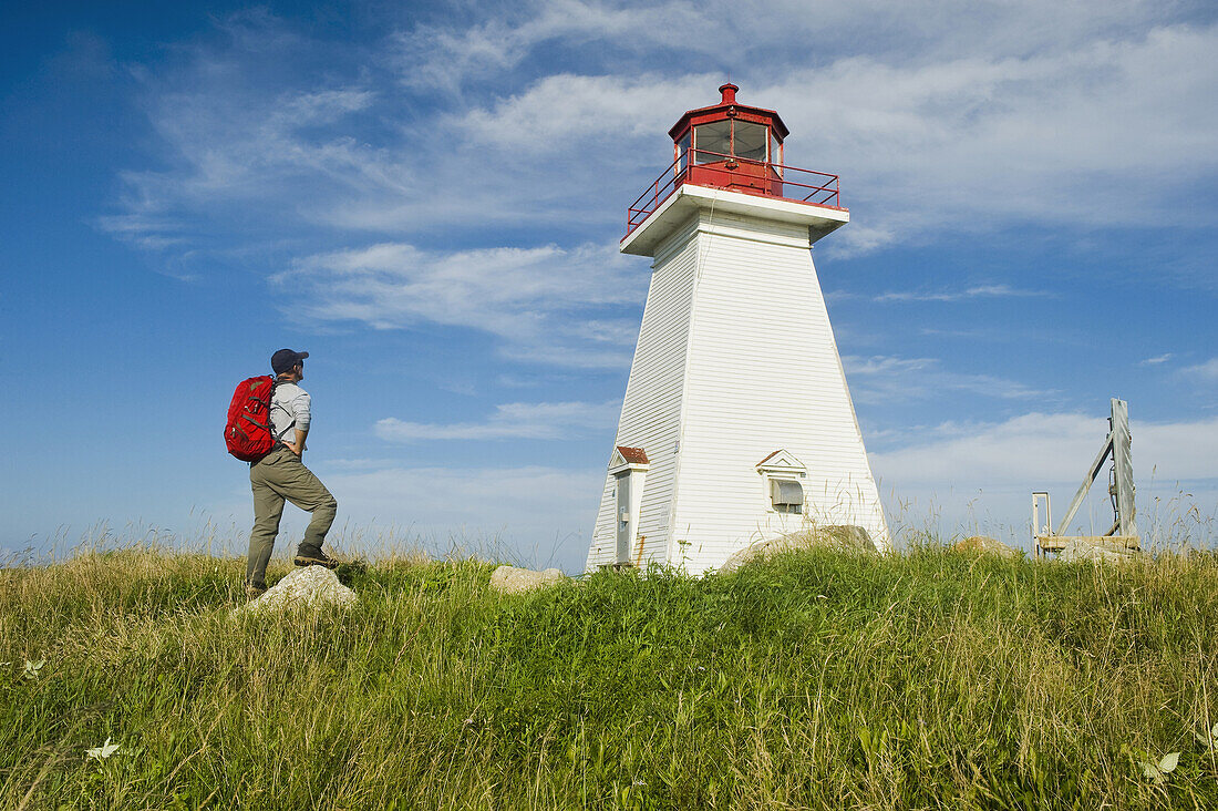 Hiker At Baccaro Point Lighthouse, Bay Of Fundy; Nova Scotia, Canada