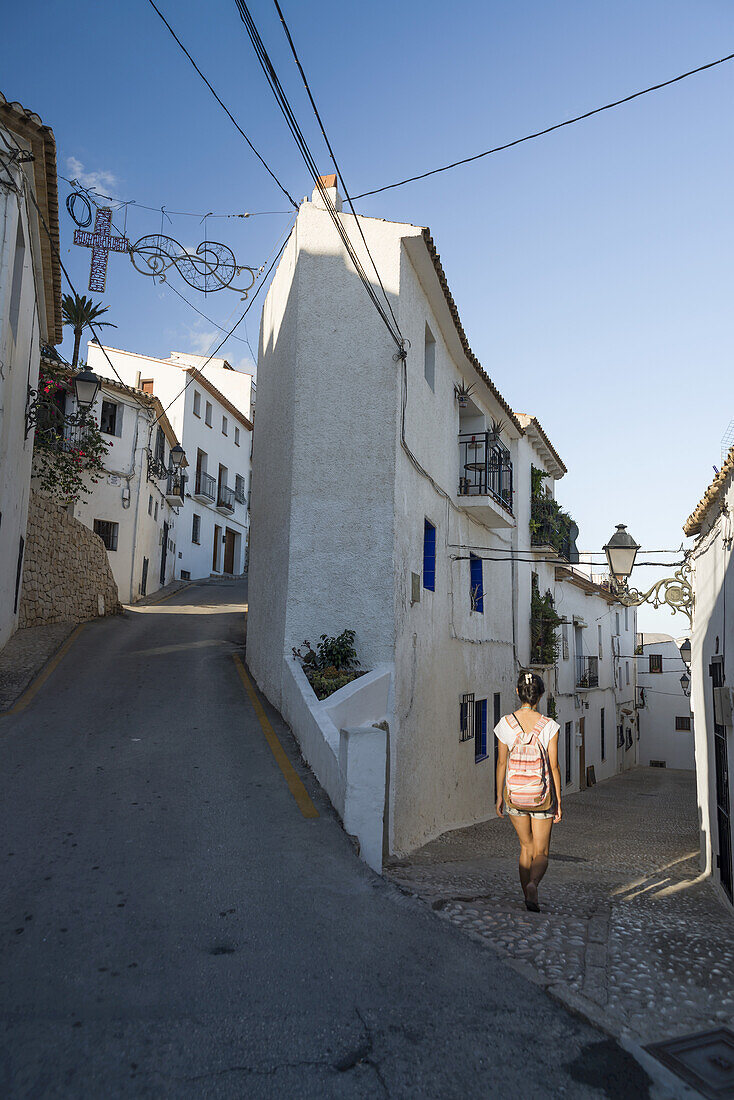 Eine chinesische junge Frau, die auf der Straße der schönen Stadt Altea an der Costa Blanca spazieren geht; Altea, Alicante, Spanien