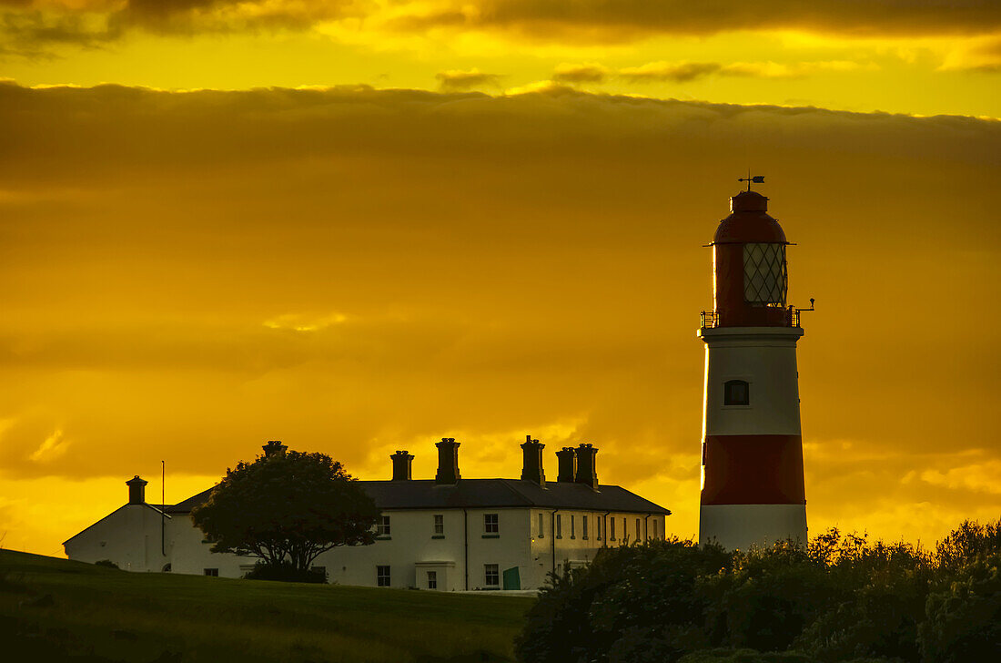 Souter-Leuchtturm unter einem glühenden goldenen Himmel bei Sonnenuntergang; South Shields, Tyne And Wear, England