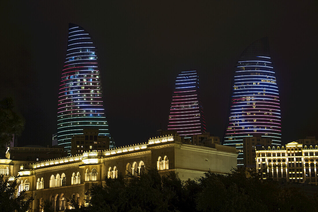 Herrenhaus in der Boyuk Qala Straße mit den Flame Towers Wolkenkratzern im Hintergrund bei Nacht; Baku, Aserbaidschan