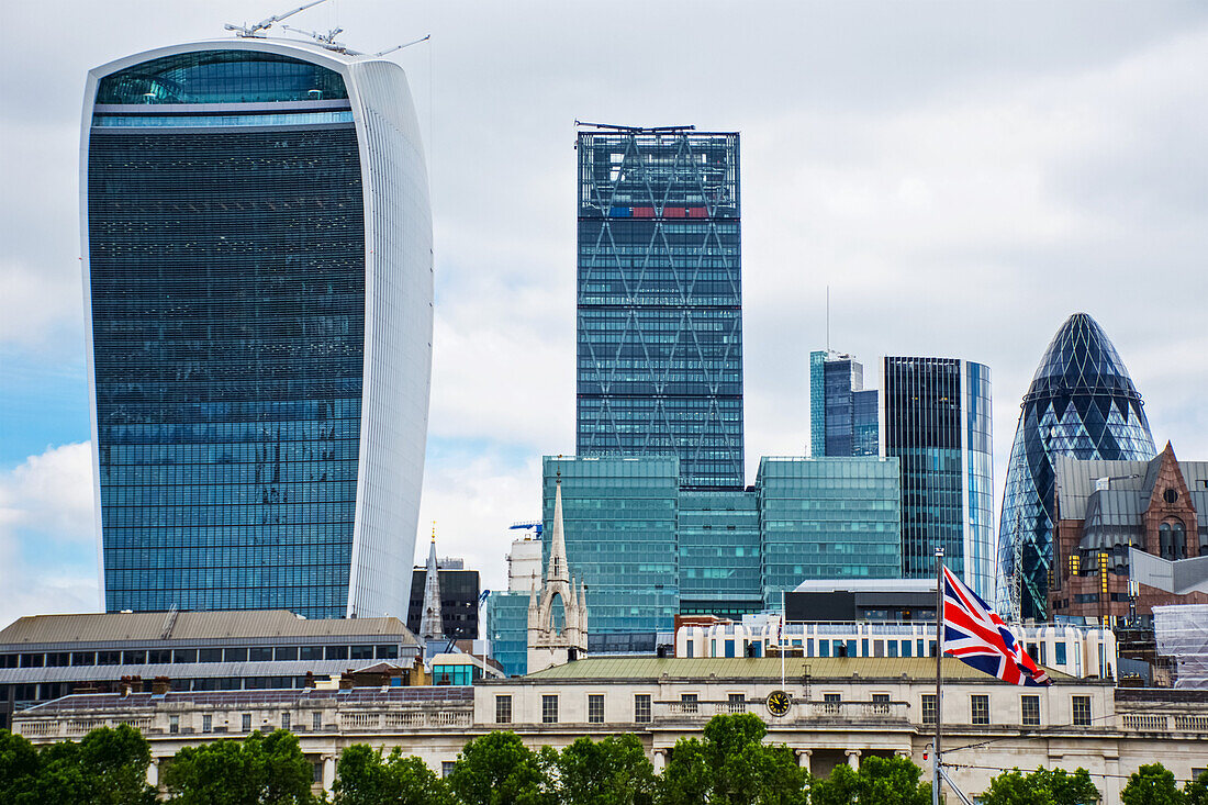 Blick über die Themse auf die Londoner City (Walkie Talkie Building und The Gherkin) und die Union Jack Flagge; London, England
