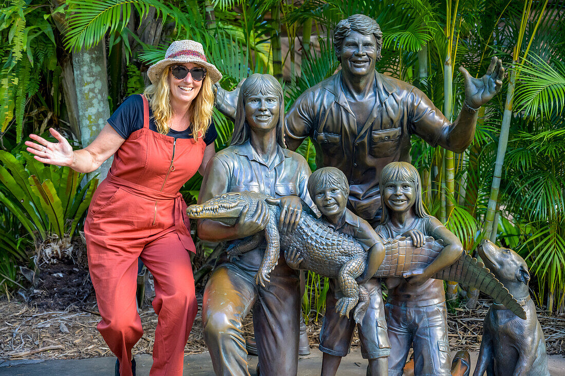 Tourist with statue of Irwin family at the zoo; Beerway, Queensland, Australia