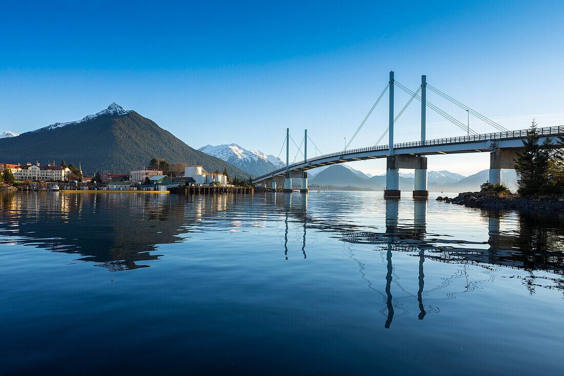 John-O'Connell-Brücke, die sich im Hafen von Sitka spiegelt, und die Stadt Sitka im Winter mit dem Berg Versovia im Hintergrund; Sitka, Alaska, Vereinigte Staaten von Amerika