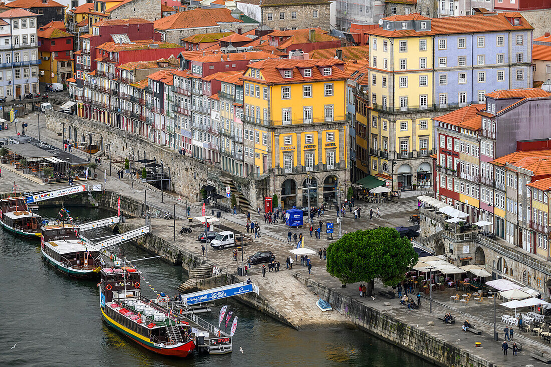 Colourful buildings and boats moored in the Douro River; Porto, Portugal