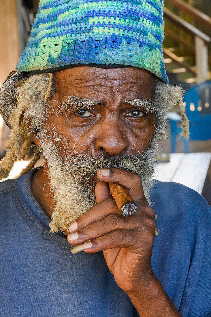 A man smokes a cigar; Roatan, Bay Islands Department, Honduras