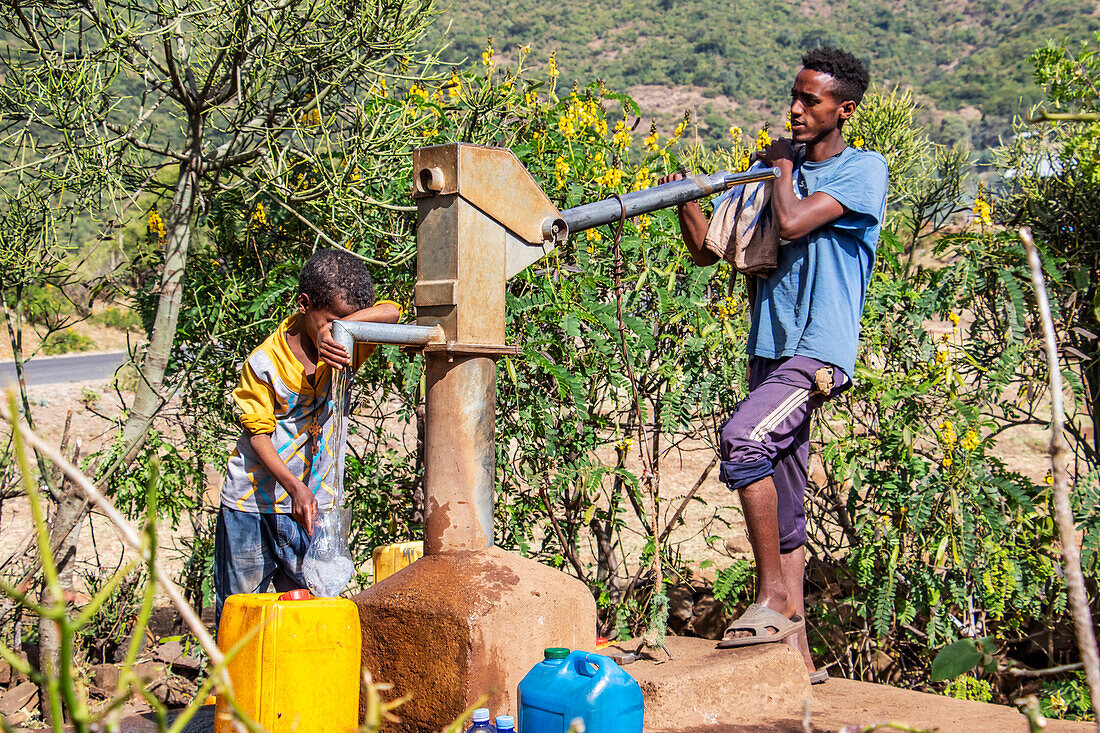 Äthiopischer Mann pumpt Wasser; Addis Zemen, Amhara-Region, Äthiopien