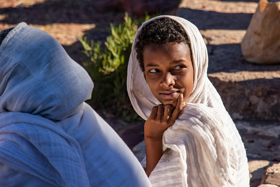 Ethiopian boy attending a prayer service outside of Abreha we Atsbeha church; Tigray Region,  Ethiopia