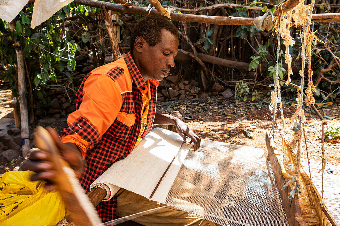 Konso-Mann beim Weben von Stoffen auf seinem Webstuhl; Karat-Konso, Region der Nationalitäten und Völker des Südens, Äthiopien