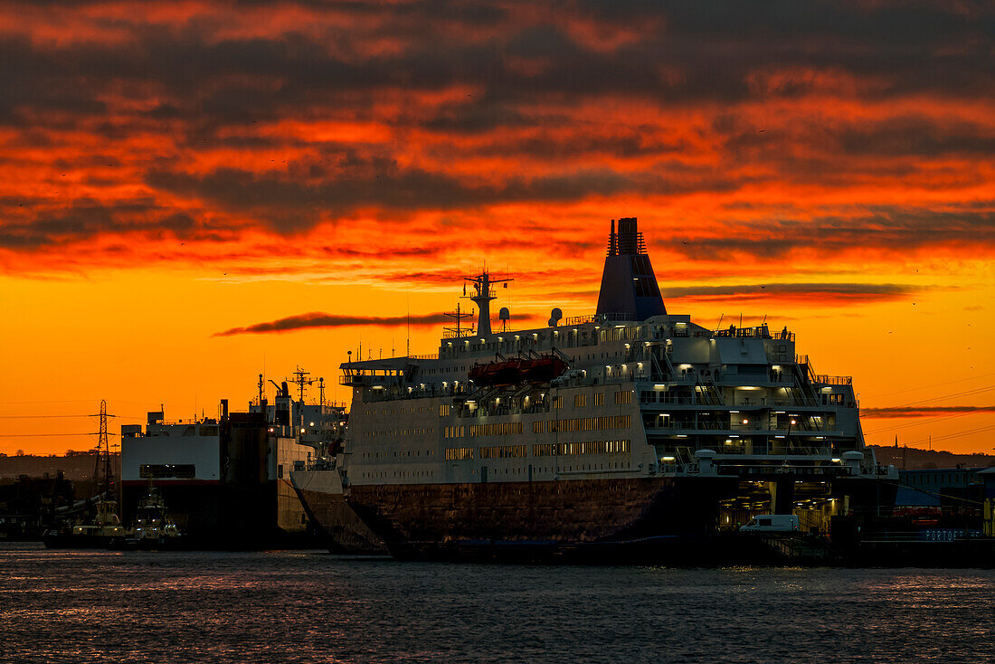 Cruise ship docked along a waterfront on the River Tyne under a brilliant sunset sky; South Shields, Tyne and Wear, England