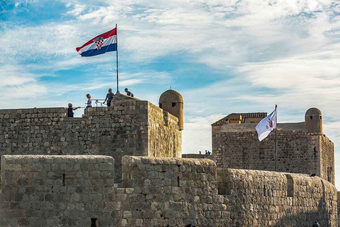 Touristen auf den Mauern einer historischen Festung mit Flagge; Dubrovnik, Gespanschaft Dubrovnik-Neretva, Kroatien