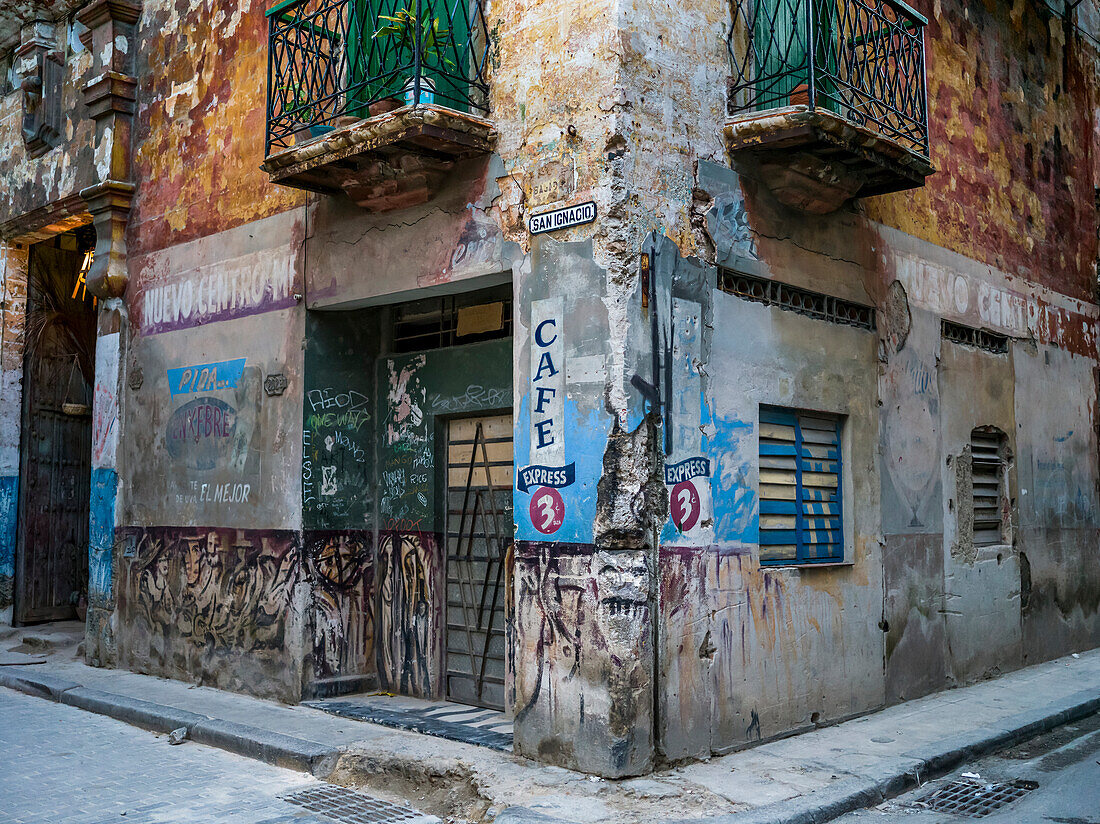 Verwitterte Fassade eines Wohnhauses mit Werbung an der Wand; Havanna, Kuba