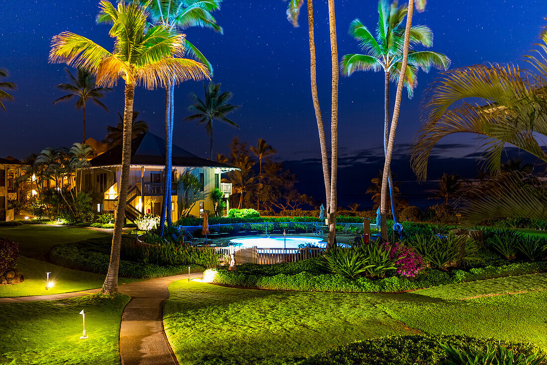 House with swimming pool and palm trees illuminated at night; Kauai, Hawaii, United States of America