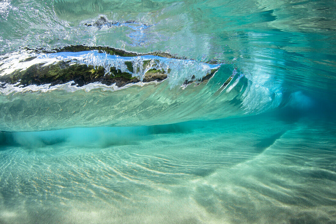 Surf crashes over a sandy bottom off the island of Maui; Maui, Hawaii, United States of America