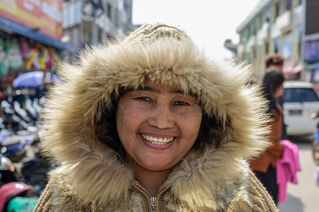 Frau mit warmem, pelzbesetztem Mantel auf dem Markt; Lashio, Shan-Staat, Myanmar
