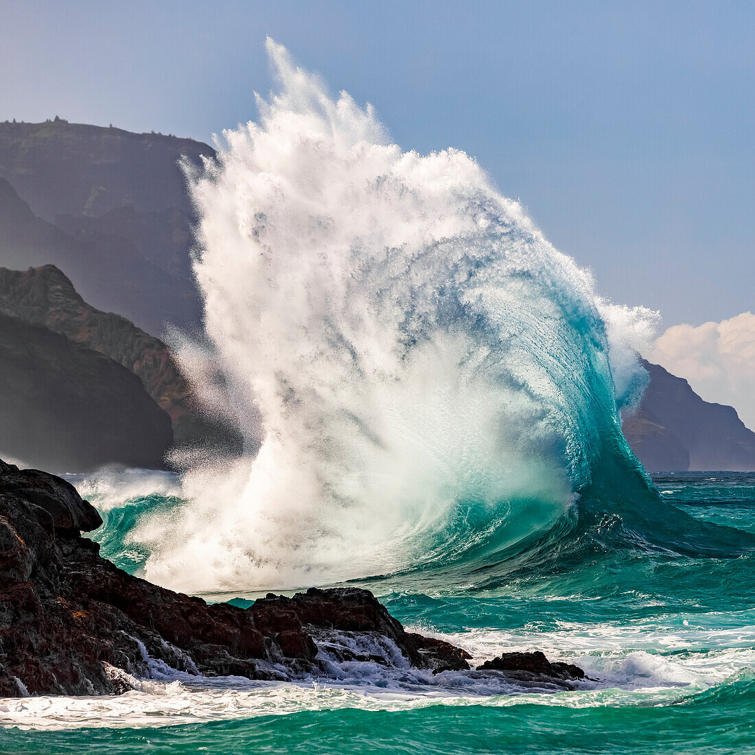 Large ocean wave crashes into rock along the Na Pali Coast; Kauai, Hawaii, United States of America