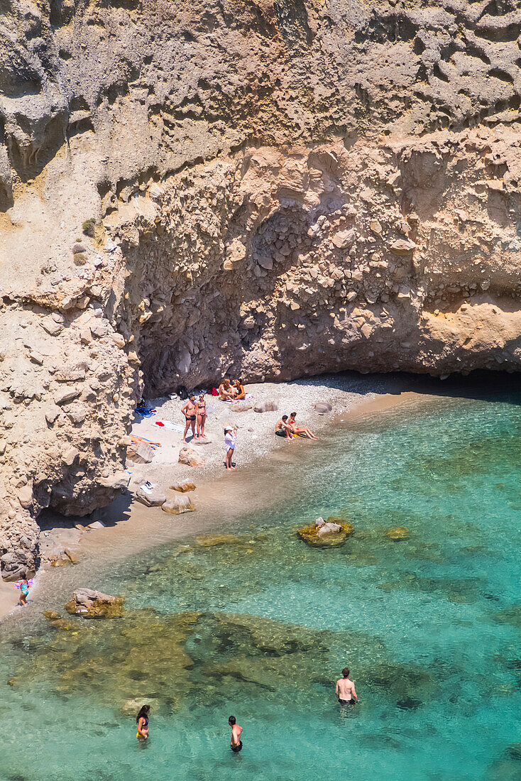 Tsigado Beach with tourists in the turquoise water; Milos Island, Cyclades, Greece
