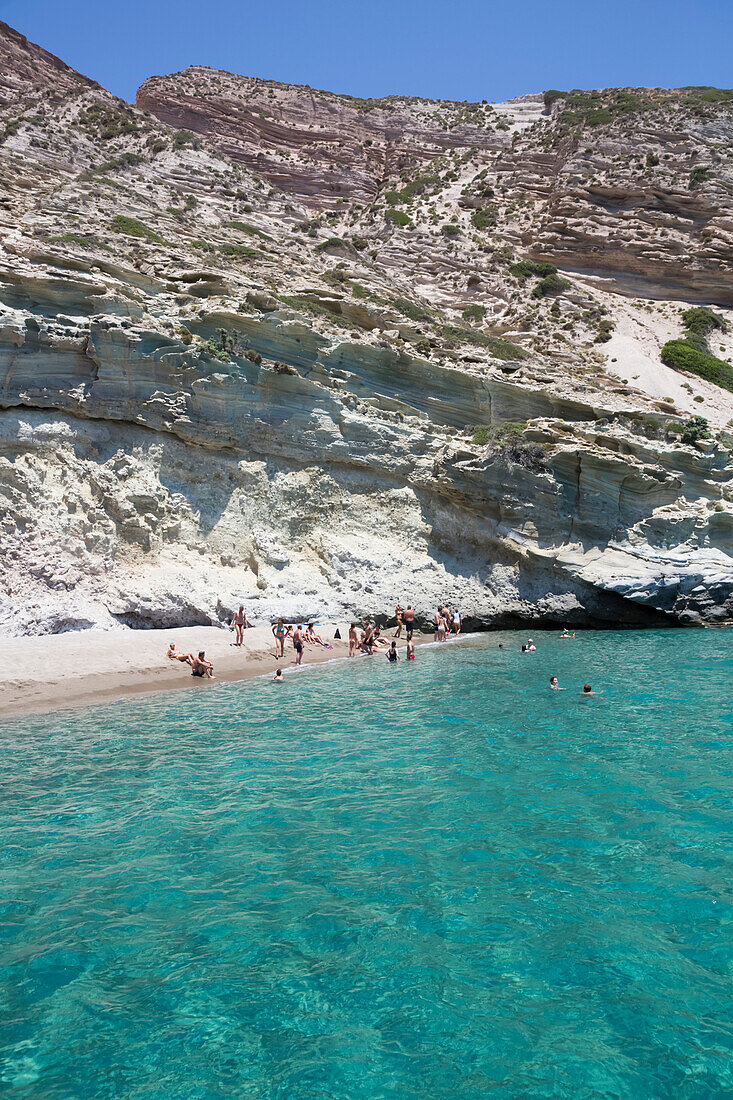 Touristen beim Schwimmen im klaren, türkisfarbenen Wasser der Bucht von Galazia Nera; Insel Polyaigos, Kykladen, Griechenland