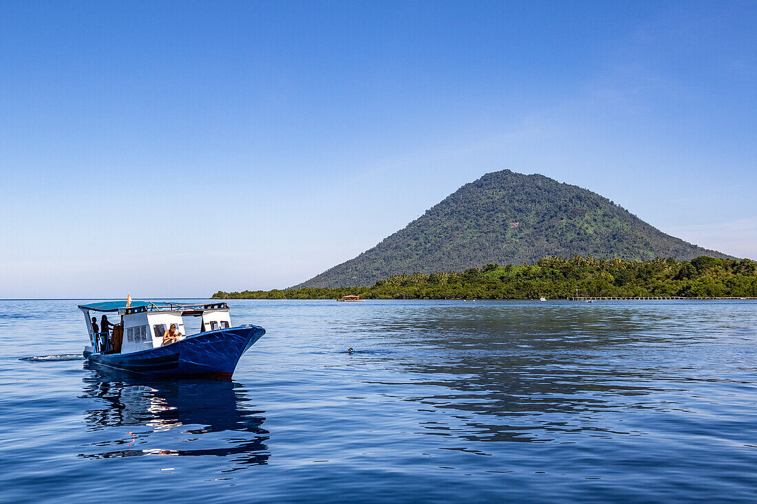 Diving boat with Manado Tua in the background, Bunaken National Marine Park; North Sulawesi, Indonesia