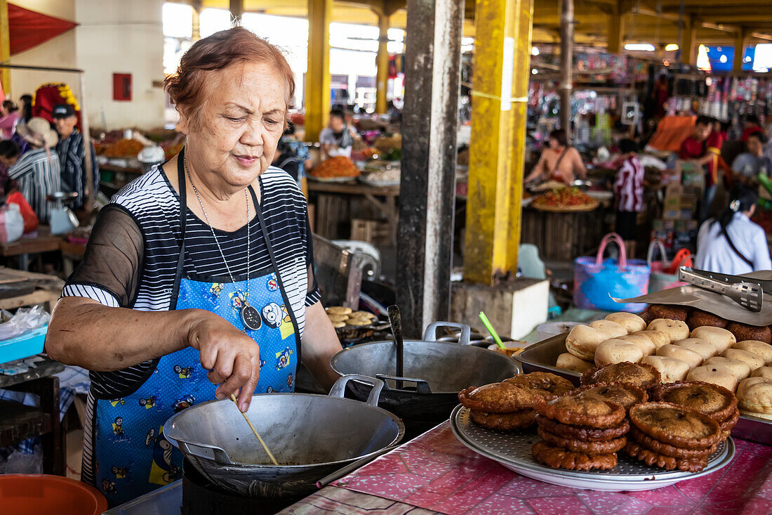 Woman preparing sweets at the Tomohon Market; Tomohon, North Sulawesi, Indonesia