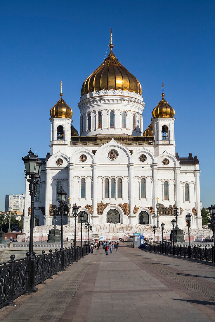 Ein langer Gang, der zur Christ-Erlöser-Kathedrale mit goldenen Zwiebeltürmen vor strahlend blauem Himmel führt, Russisch-Orthodoxe Kirche (Moskauer Patriarchat); Moskau, Russland
