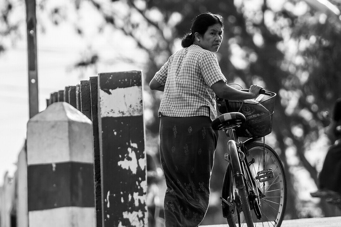 Black and white image of a Burmese woman with a bicycle; Yawngshwe, Shan State, Myanmar