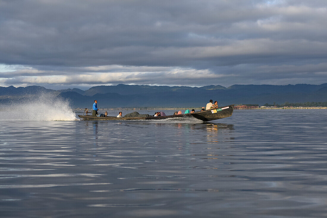 A motorboat transports passengers across Inle Lake; Yawngshwe, Shan State, Myanmar