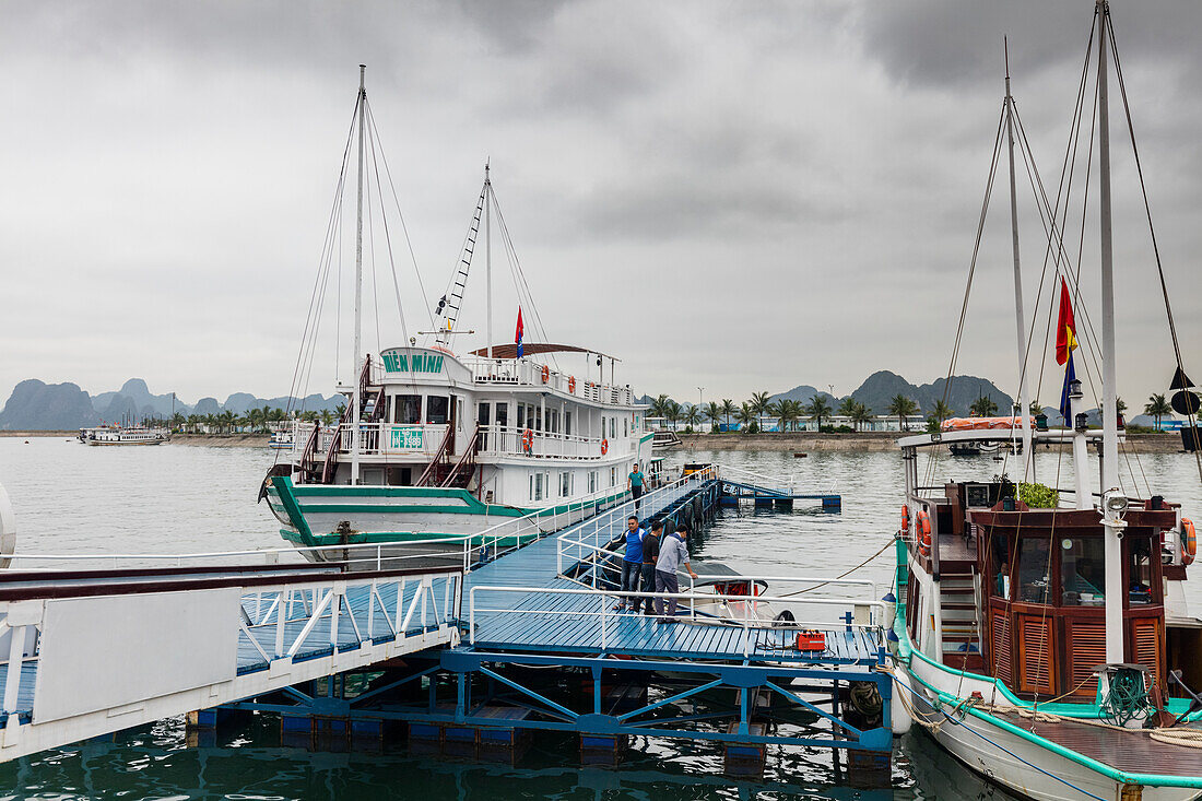 Ausflugsboot und Fischerboot an einer Anlegestelle in der Ha Long Bay; Provinz Quang Ninh, Vietnam